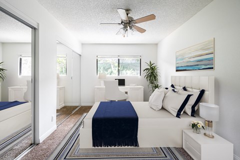a bedroom with a bed and a ceiling fan