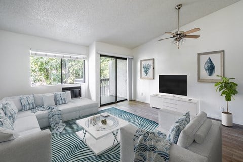 a living room with a white couch and a tv