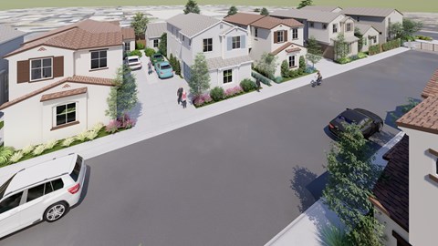 A street view of a residential area with houses and cars.