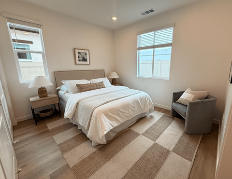 A bedroom with a large bed and a chair.