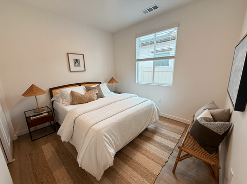 A bedroom with two beds and a chair.