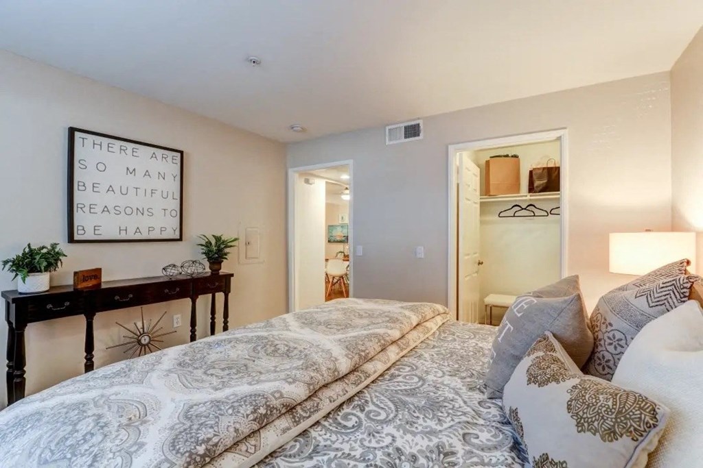 a bedroom with a bed and a desk and a mirror