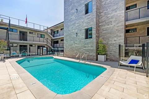 A swimming pool in a courtyard surrounded by buildings.