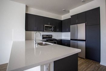 a kitchen with black cabinets and a white counter top