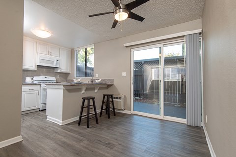 A kitchen with white cabinets and a bar stool.