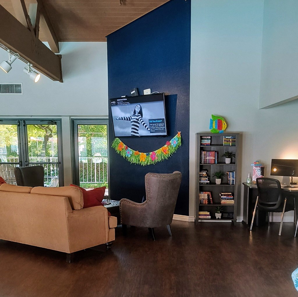 a living room with couches chairs and a tv on the wall