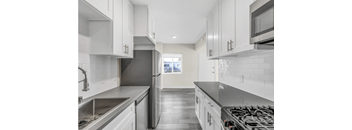 A modern kitchen with stainless steel appliances and white cabinets.