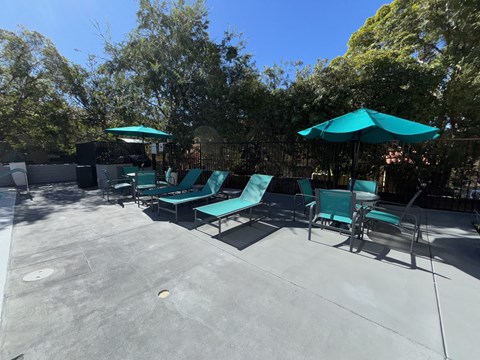 A sunny day at the outdoor seating area with green chairs and umbrellas.