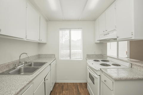A kitchen with white cabinets and a granite countertop.