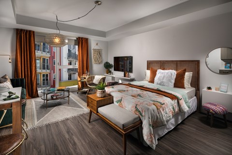 A bedroom with a large bed and a chair.