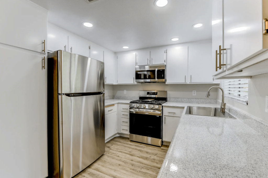 a kitchen with white cabinetry and white quartz countertops