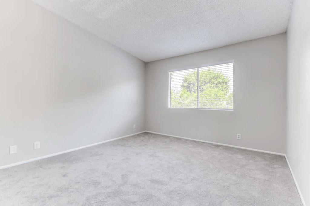 an empty bedroom with a large window