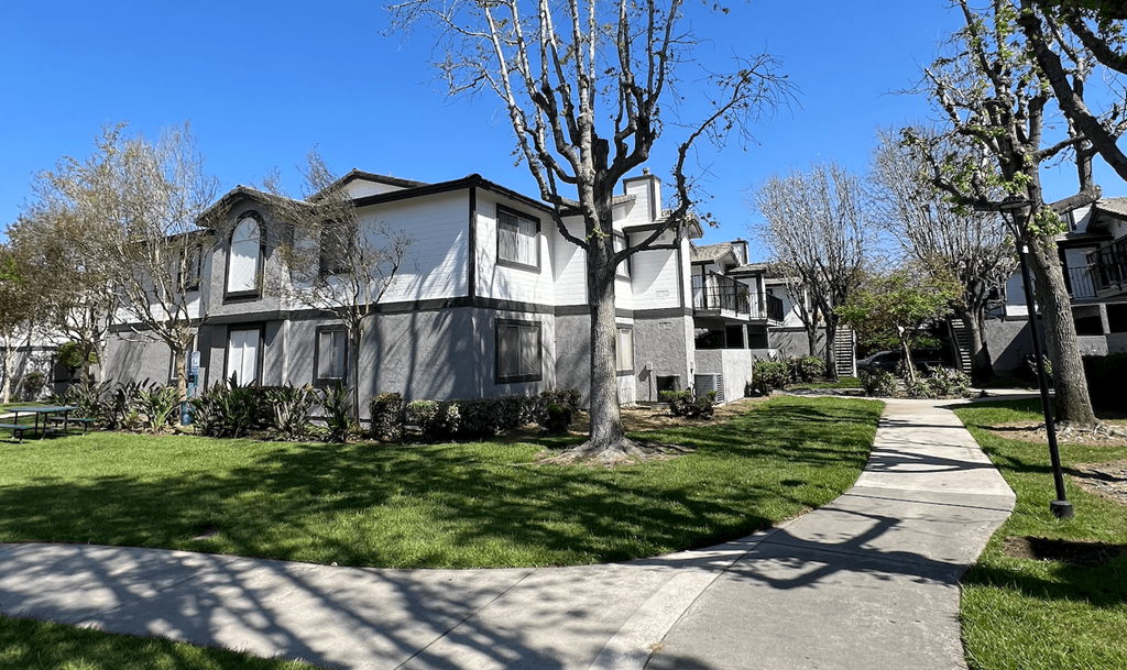 an apartment building with a sidewalk in front of it