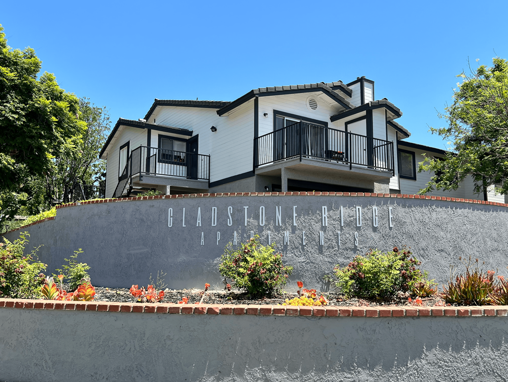 a retaining wall with a house behind it
