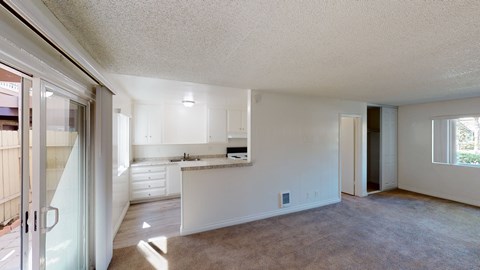 the living room and kitchen of an empty apartment