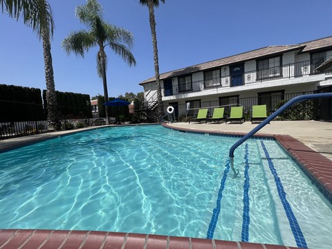 A swimming pool with a blue tiled edge and a red brick border.
