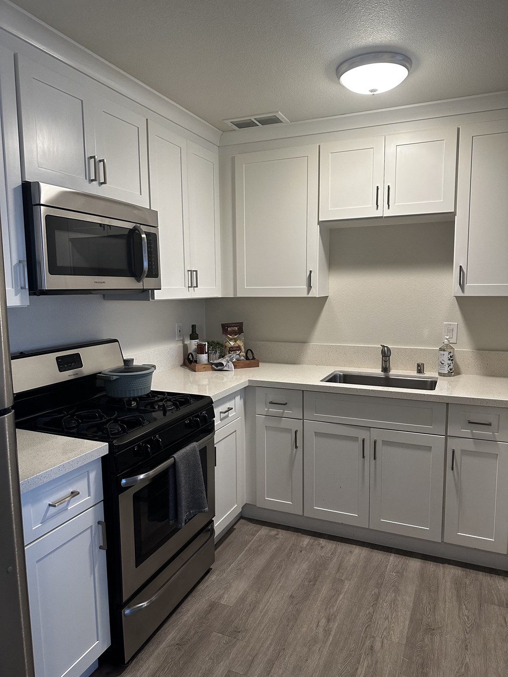 a kitchen with white cabinets and stainless steel appliances
