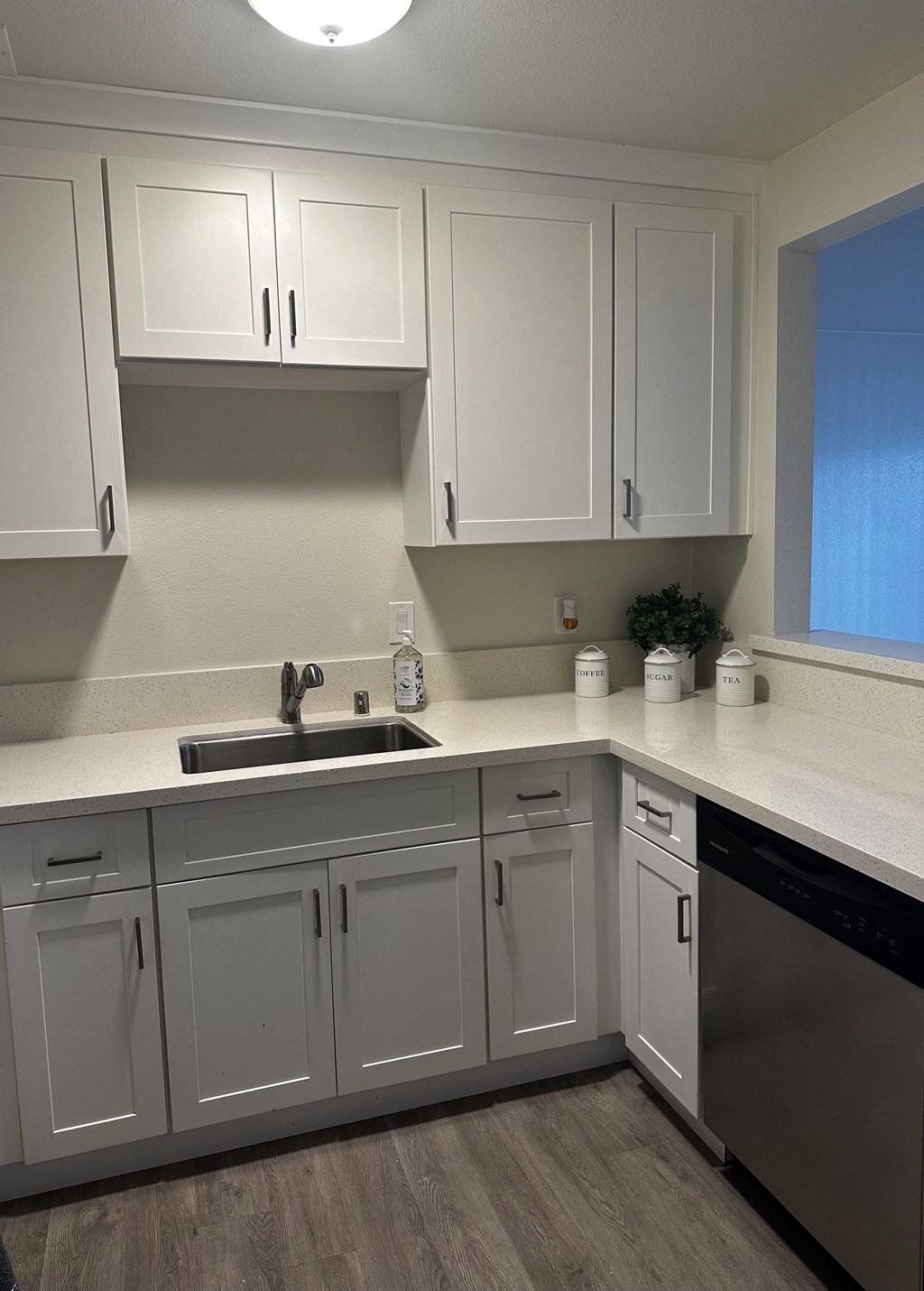 an empty kitchen with white cabinets and a sink