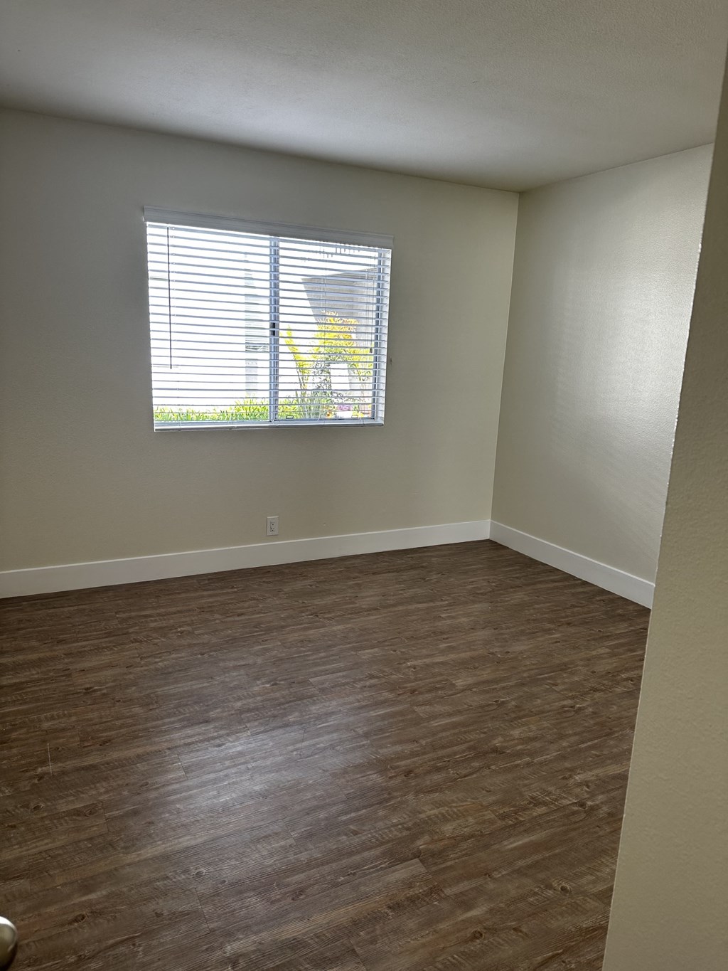 an empty room with wood floors and a window