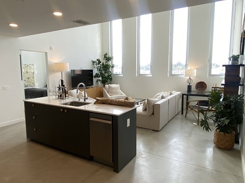 a living room with a kitchen and a couch and a tv