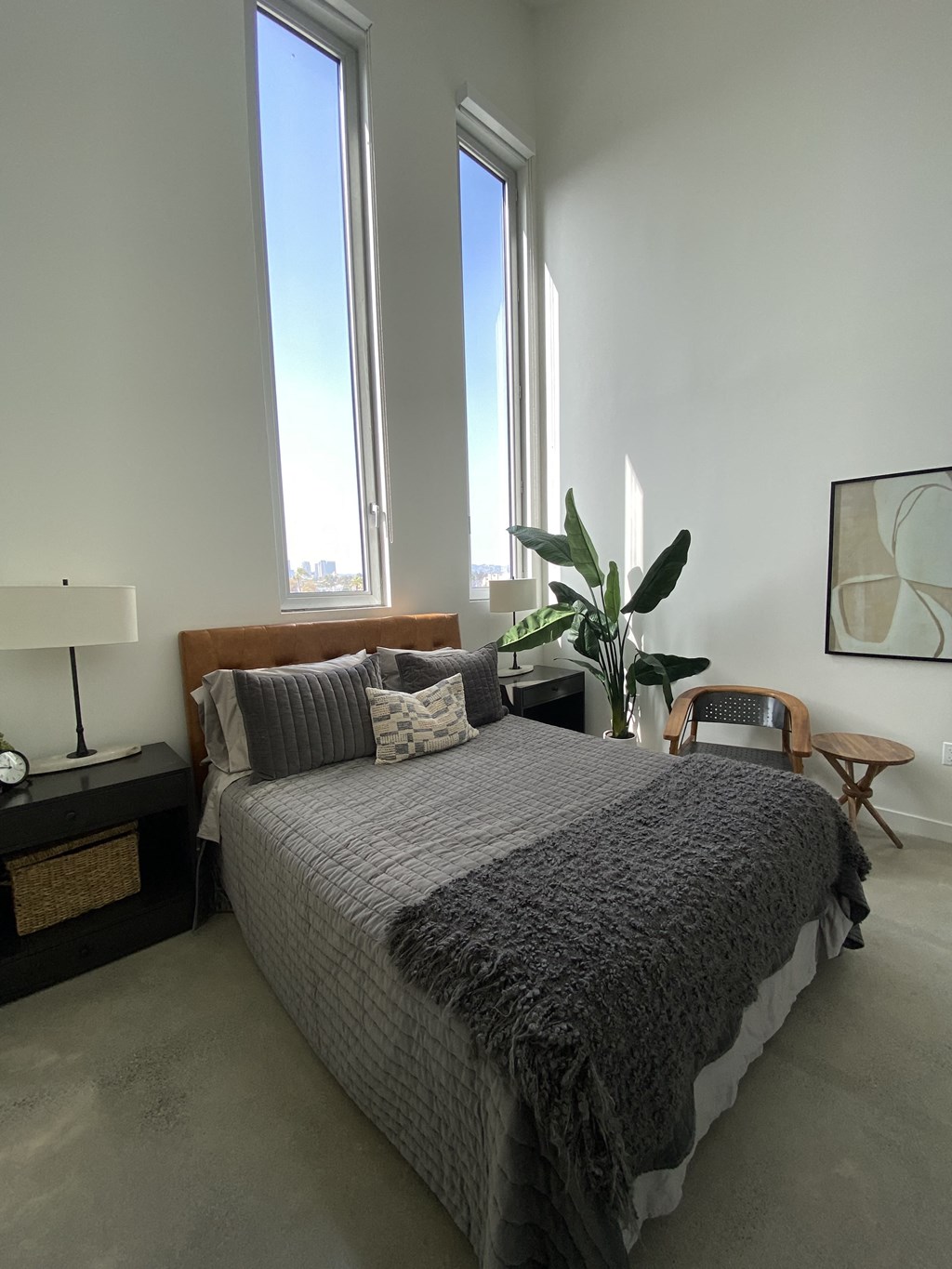 a bedroom with a large bed and two tall windows