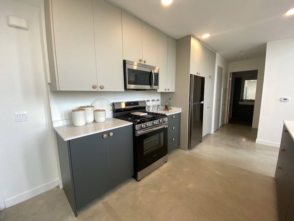 a kitchen with white cabinets and a stove and a microwave