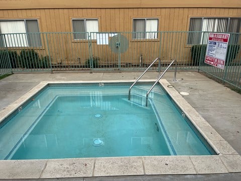 an empty swimming pool in front of a building