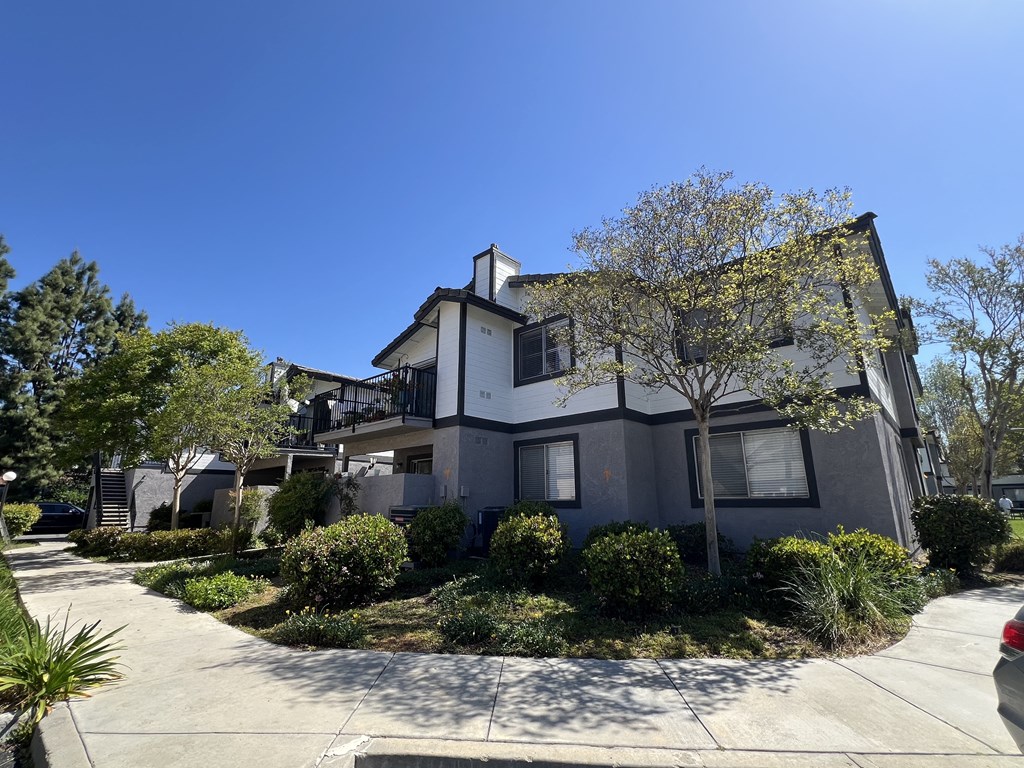 a grey and with a sidewalk in front of it
