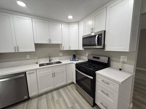 A kitchen with white cabinets and stainless steel appliances.