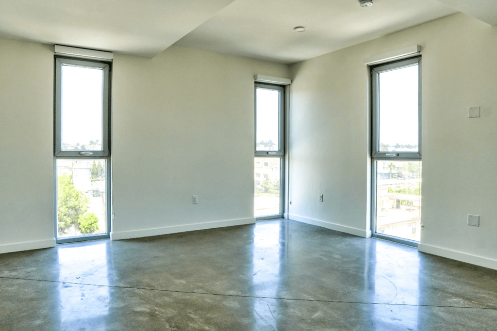 an empty living room with white walls and a concrete floor
