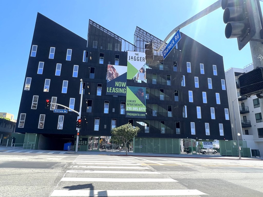 a black building on the corner of a street with a traffic light in front of it