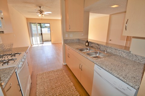 an empty kitchen with granite counter tops and white appliances