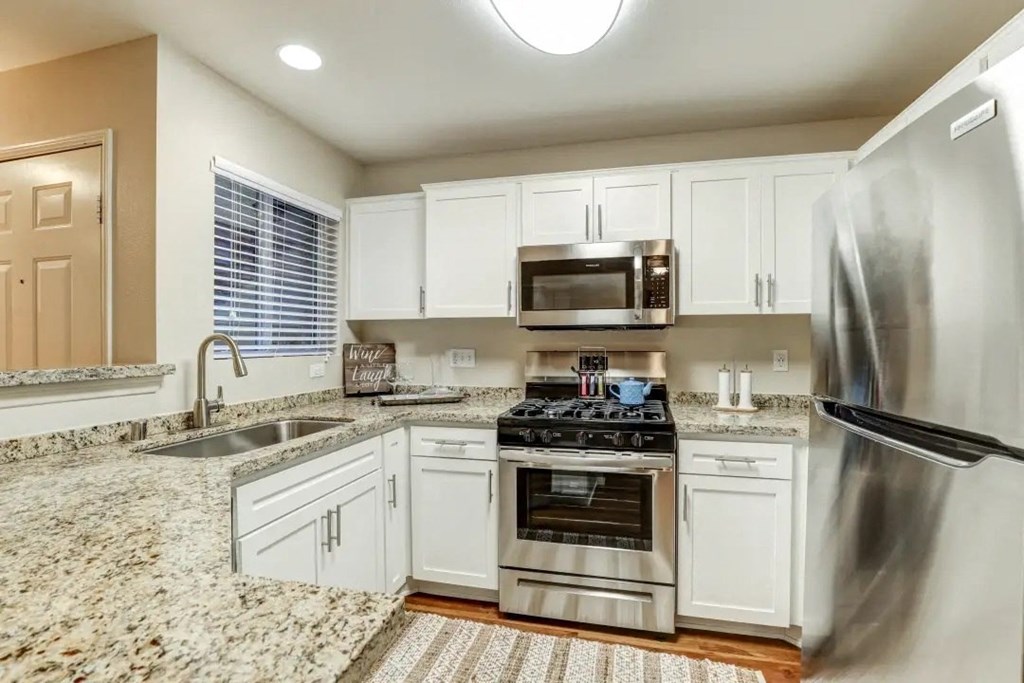 a kitchen with stainless steel appliances and white cabinets