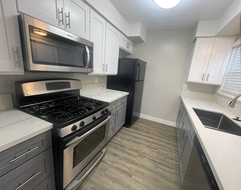 A kitchen with a black refrigerator and stove.