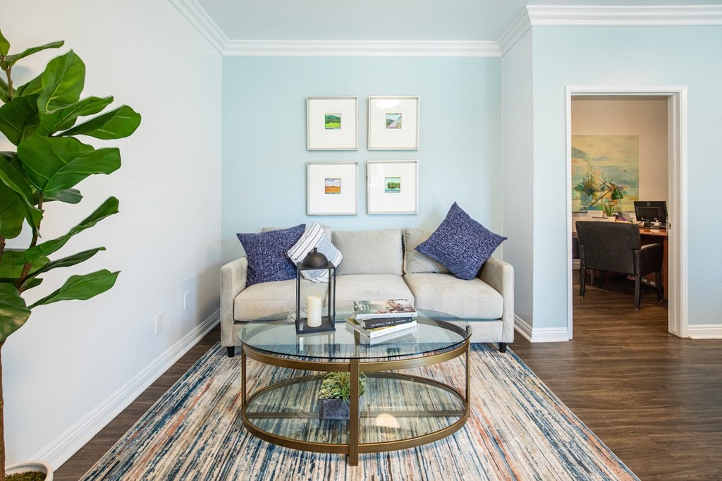 a living room with blue walls and a glass coffee table
