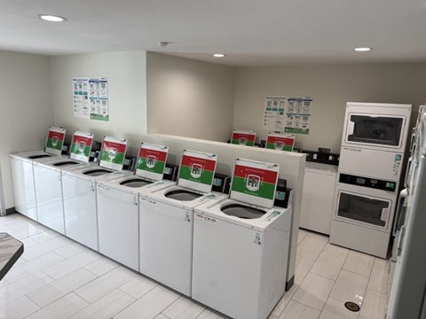 A row of washing machines are lined up in a laundromat.