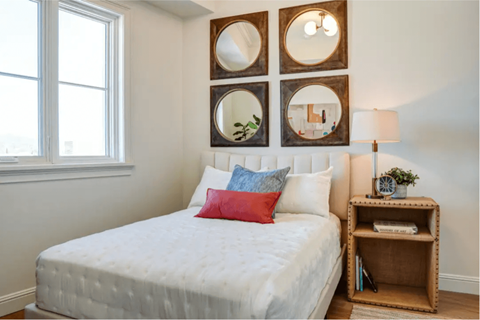 a bedroom with a white bed and mirrors on the wall