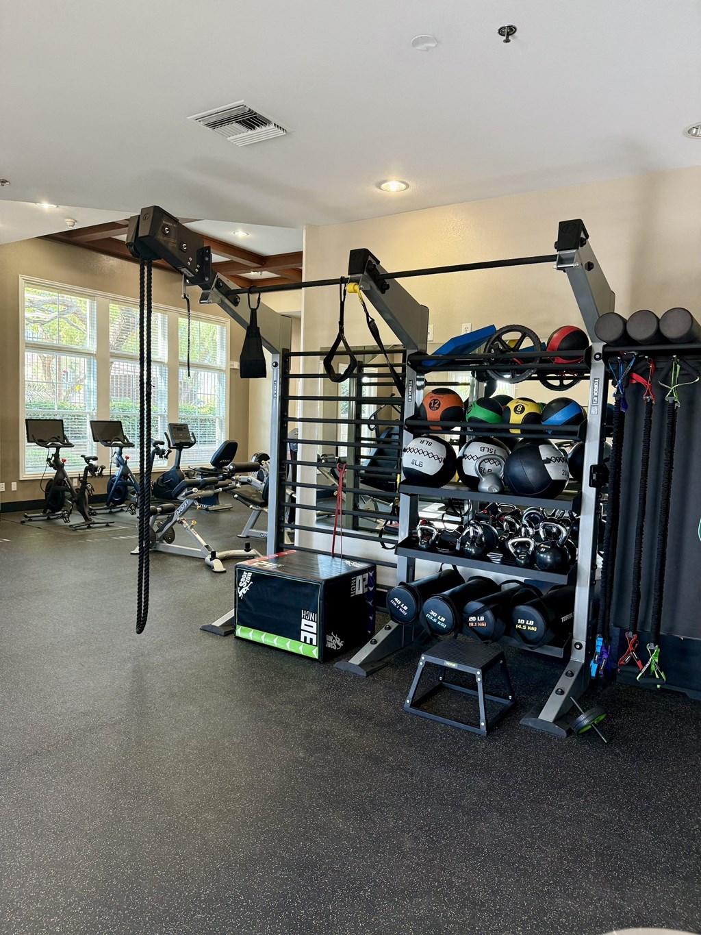 a home gym with weights and equipment and a large window