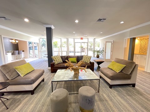 A living room with grey couches and a glass coffee table.