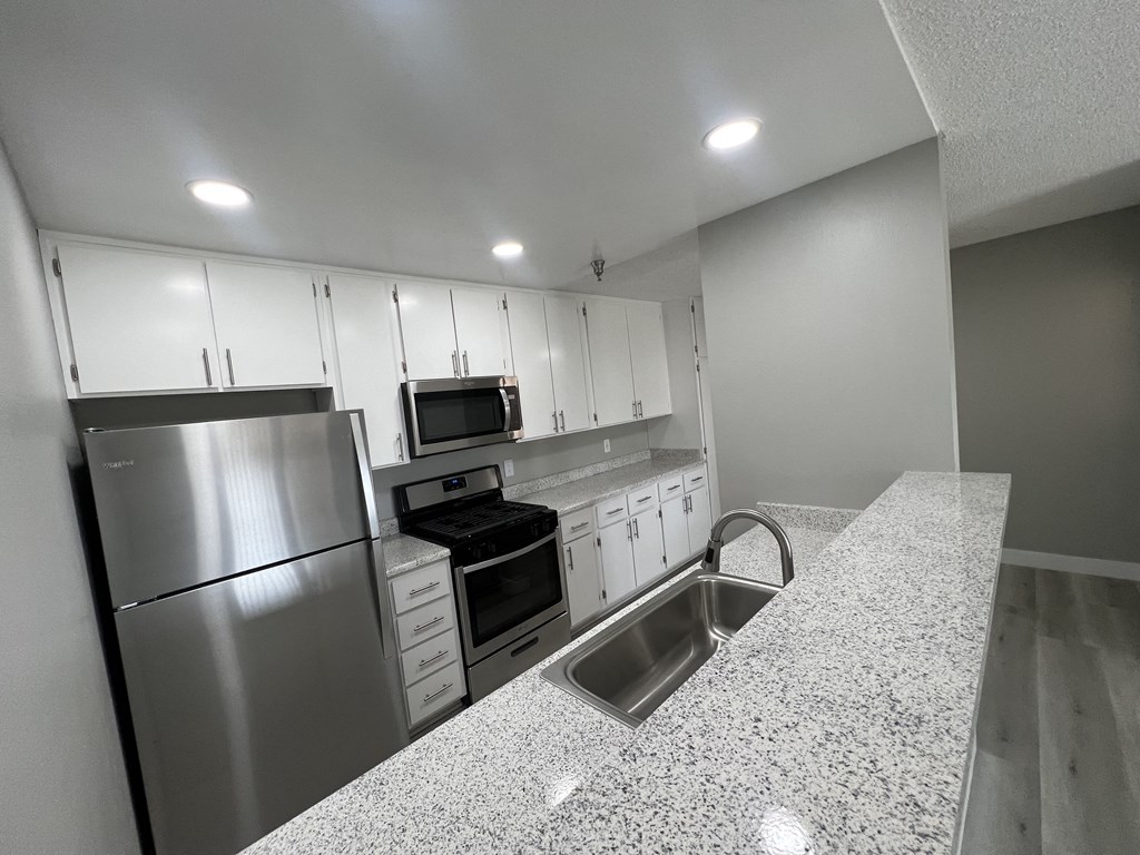 a kitchen with granite countertops and stainless steel appliances