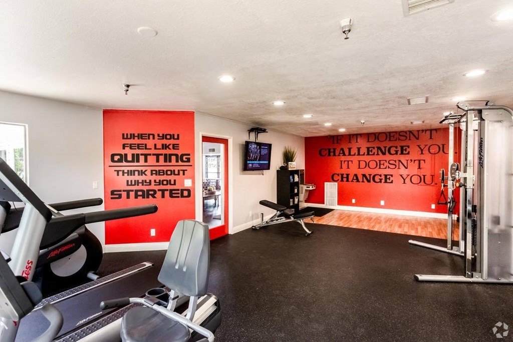 a home gym with exercise equipment and a motivational quote on the wall