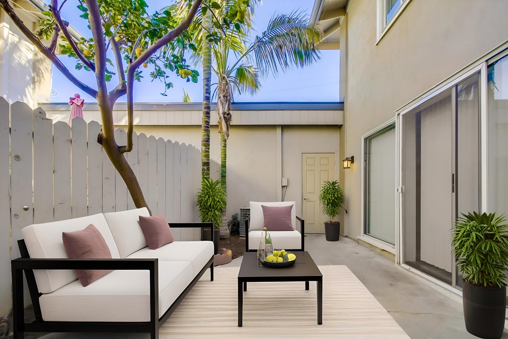 A patio with a white couch and a black table.