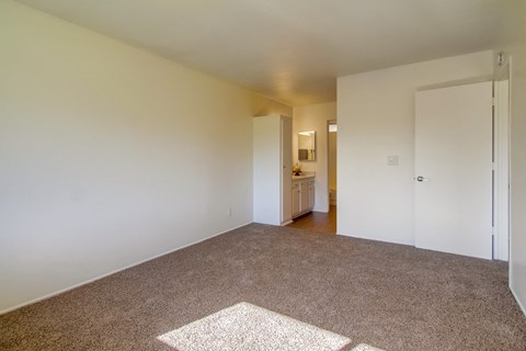 an empty living room with carpet and white walls