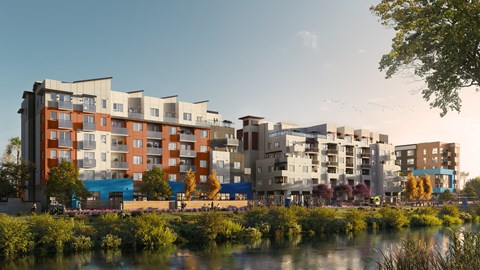 A modern apartment complex is situated by a river.