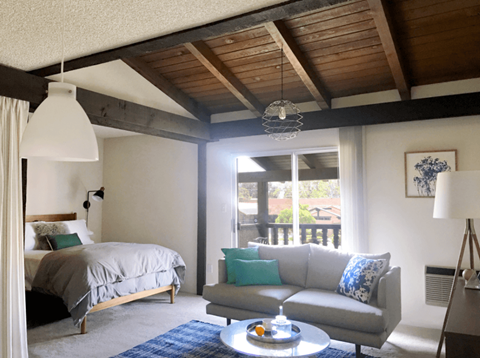 A bedroom with a bed, a couch, and a table.