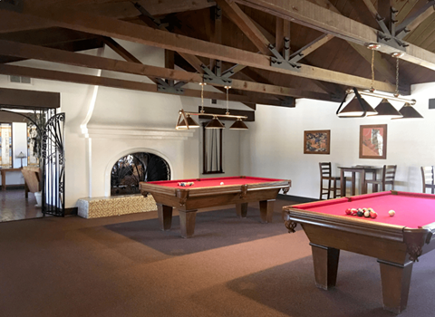 A room with a pool table and a fireplace.