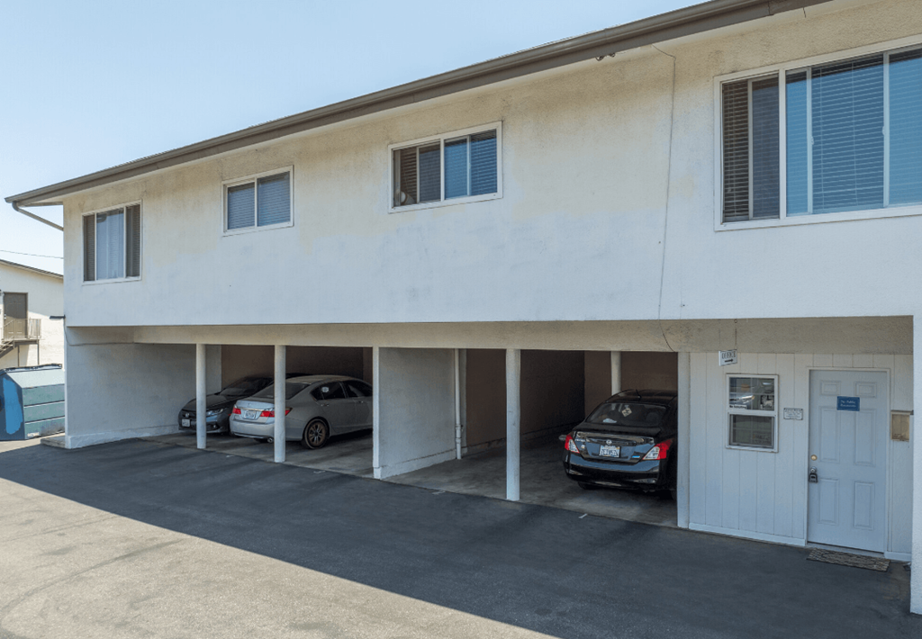the outside of a building with cars in the parking lot