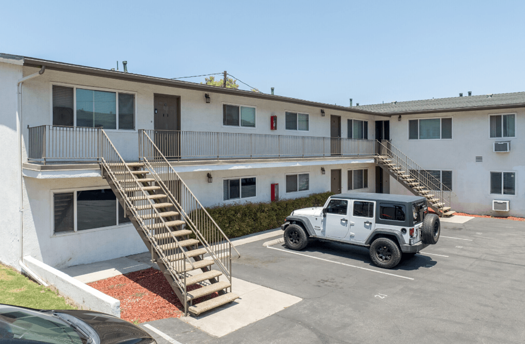 an apartment building with a jeep parked in front of it