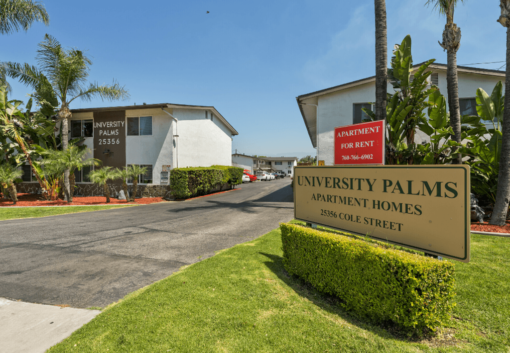 a sign for the university palms apartment homes on the side of a road