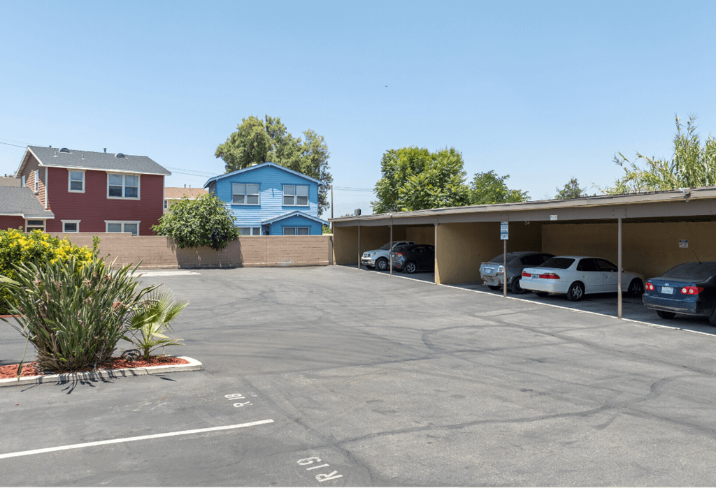 a parking lot with a building and cars in front of it
